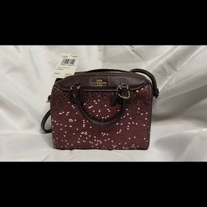 Tiny burgundy Coach purse with shoulder strap